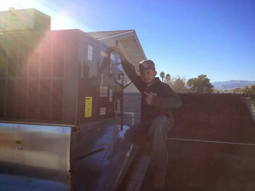 HVAC technician performing Boiler Repair on a rooftop unit in Bullskin
